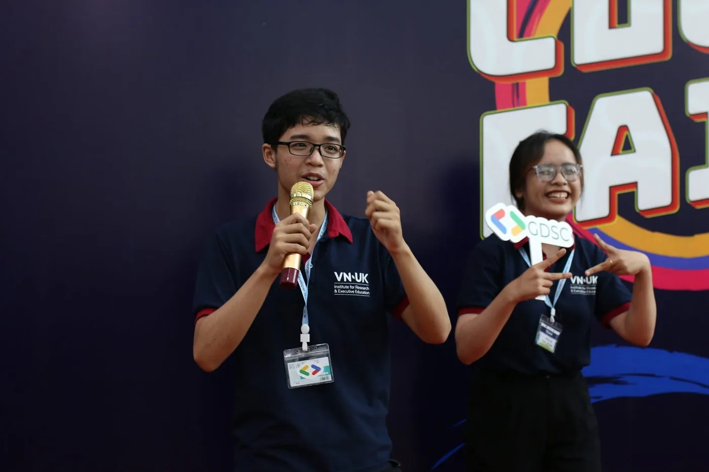 Lucas on stage with a microphone at a Wildcats event